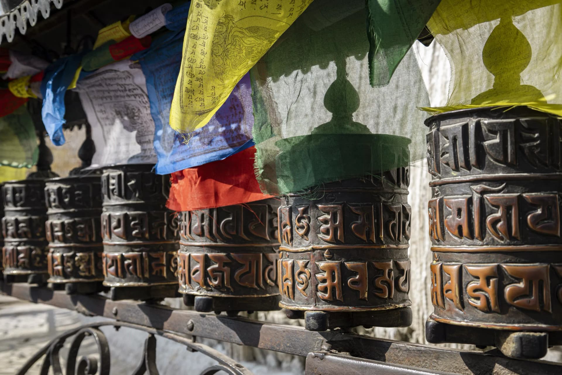 Prayer flags strung above traditional prayer bells