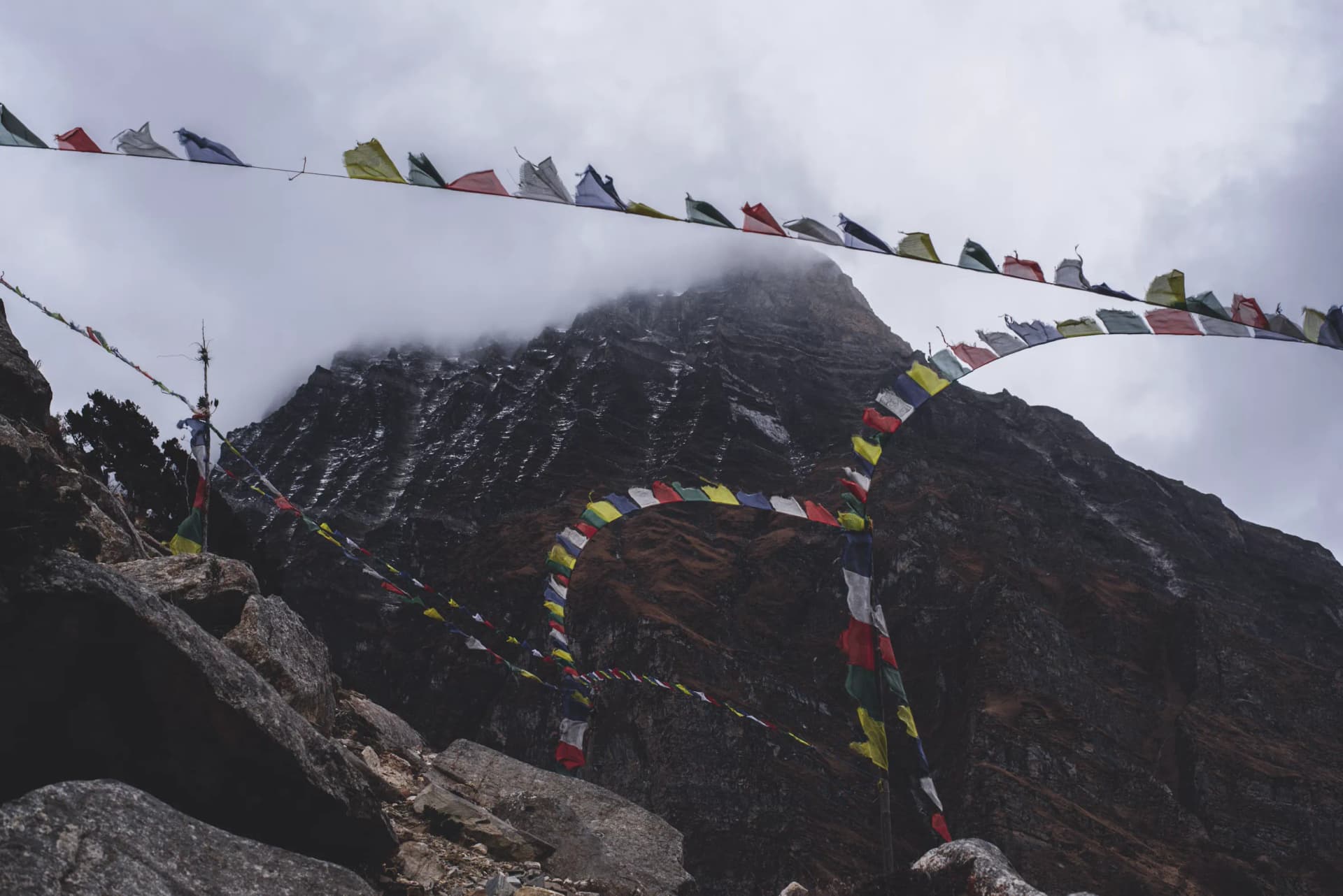 Prayer flags fluttering in the wind with a mountain backdrop